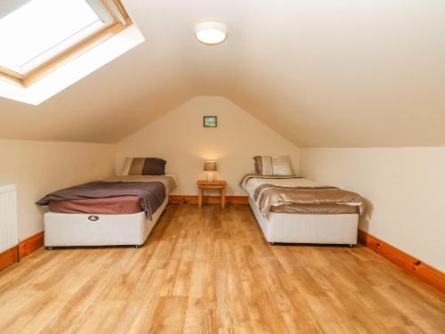 Cette chambre mansardée dispose de 2 lits et de parquet. dans l'établissement Clogher Cottage, à Doonbeg