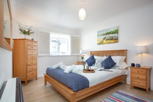 a bedroom with a large bed and a dresser at The Sail Loft in Sidmouth