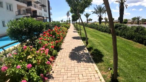 a brick pathway with flowers next to a building at Great seaview appartments in Thalassa in Vokolidha