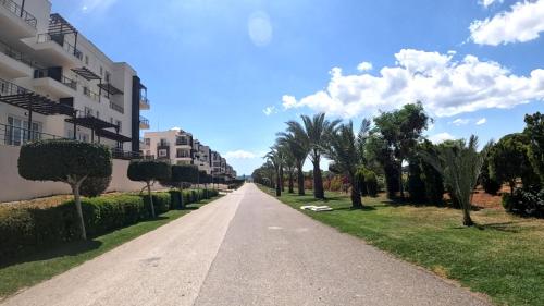 an empty street with palm trees and buildings at Great seaview appartments in Thalassa in Vokolidha