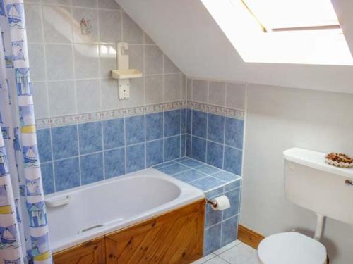 a bathroom with a bath tub and a toilet at Reeks Cottage in Killorglin