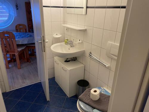 mała łazienka z umywalką i toaletą w obiekcie Seeblick Wohnung 112 mit Ostseeblick w Koserowie