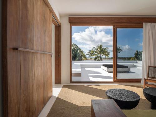 a living room with a sliding glass door with a view at KA BRU Beach Boutique Hotel in Barra Grande