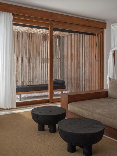 a living room with a couch and two tables at KA BRU Beach Boutique Hotel in Barra Grande