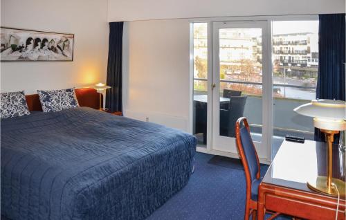 a hotel room with a bed and a desk and a window at Amazing Apartment In Helsingr With 3 Bedrooms And Wifi in Helsingør