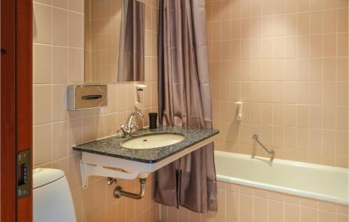 a bathroom with a sink and a bath tub at Amazing Apartment In Helsingr With 3 Bedrooms And Wifi in Helsingør