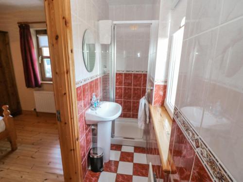 a bathroom with a sink and a tub and a toilet at Bluebell House and Gardens in Rossbrin