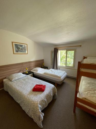 une chambre d'hôtel avec deux lits et une fenêtre dans l'établissement Mas des Amarens, à Malaucène