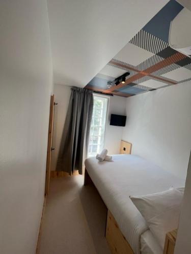 a bedroom with two beds and a ceiling at easyHotel Paddington in London
