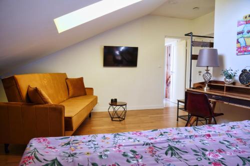 ein Schlafzimmer mit einem Bett, einem Sofa und einem Schreibtisch in der Unterkunft Villa Pro Musica - apartamenty, śniadania in Lębork