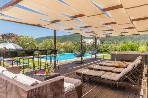 una terrazza all'aperto con mobili da giardino e piscina di Villa Sand Dune ad Agios Georgios