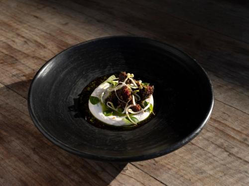a black bowl with food in it on a table at KA BRU Beach Boutique Hotel in Barra Grande