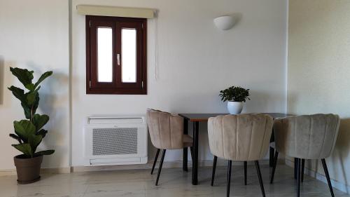 a dining room with a table and chairs and a window at Kallistis Beach House in Monolithos