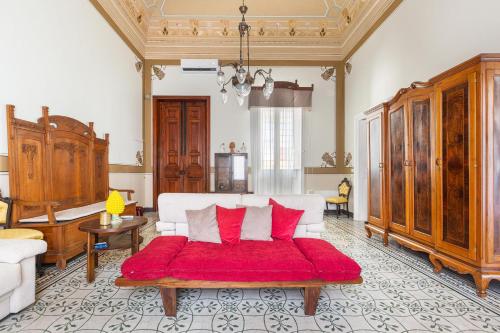Sala de estar con cama con manta roja en Bianco Liberty by BarbarHouse, en Trepuzzi