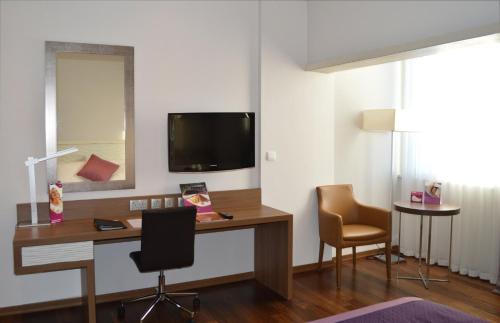 a room with a desk with a television and two chairs at Crowne Plaza Limassol by IHG in Limassol
