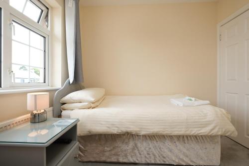 a small bedroom with a bed and a glass table at Four Seasons B&B in Galway
