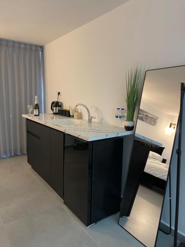 a kitchen with a counter with a sink and a mirror at K.suites סוויטות בוטיק in Bet Sheʼan