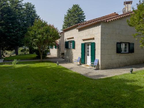 ein kleines Haus mit zwei Stühlen im Hof in der Unterkunft Retiro do Prior in Chaves