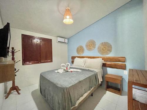 1 dormitorio con 1 cama con pared azul en Bangalos do Pontal en Japaratinga