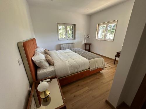 a small bedroom with a bed and two windows at Retiro do Prior in Chaves