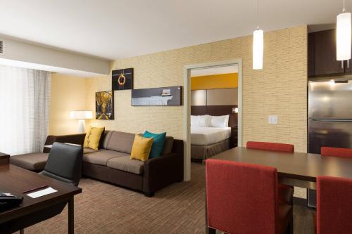 a living room with a couch and a room with a bed at Residence Inn by Marriott Denver Central Park in Denver