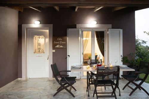 a dining room with a table and some chairs at Villa Sand Dune in Agios Georgios