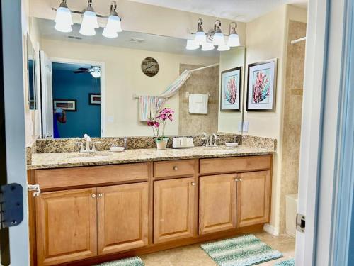 ein Badezimmer mit einem Waschbecken und einem großen Spiegel in der Unterkunft Resort style home across from the clubhouse. in Kissimmee