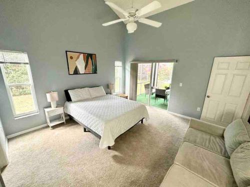 - une chambre avec un lit, un canapé et un ventilateur de plafond dans l'établissement Modern Brand New Home 20mins DisneyParks, à Davenport