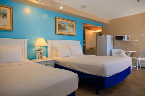 a hotel room with two beds and a refrigerator at The White Sands Resort and Spa in Point Pleasant Beach
