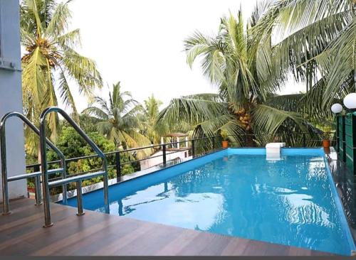 a pool on the balcony of a hotel with palm trees at Bella vista in Candolim