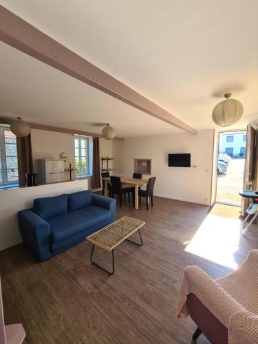 a living room with a blue couch and a table at Maison Huchet à 10min du parc le Puy duFou in Mallièvre