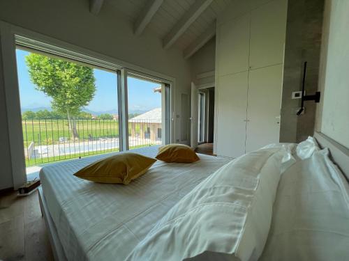 a large bed in a room with a large window at Casa Vola Bisalta in Cuneo