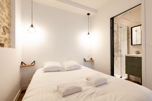 - une chambre avec 2 lits blancs et une salle de bains dans l'établissement L'Hermine - Coquet - Port - Linge inclu, à Vannes