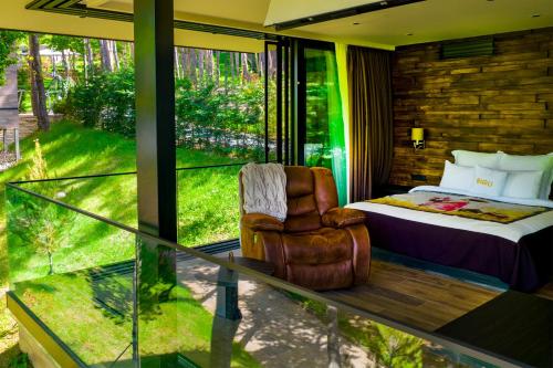 une chambre avec un lit, une chaise et une fenêtre dans l'établissement Bioli Wellness Resort, à Kojori