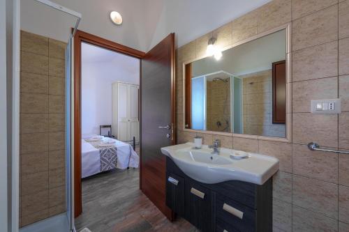 a bathroom with a sink and a mirror at Casa Lentischio piscina evista mare in Aglientu