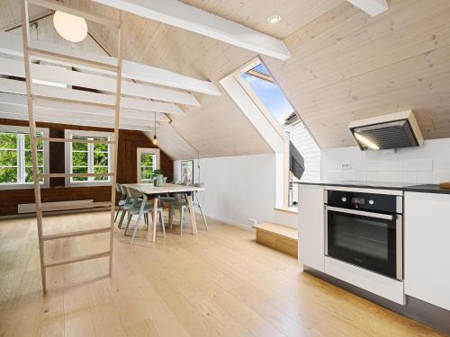 スタヴァンゲルにあるCharming Rooftop Apartment In Heart Of Stavangerのキッチン(コンロ、テーブル、椅子付)