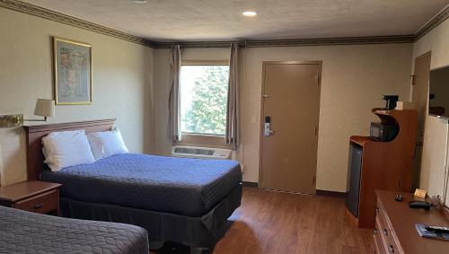 a hotel room with a bed and a window at Magnuson Grand Harrisburg in New Cumberland