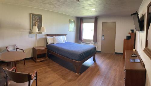 a bedroom with a bed and a table in a room at Magnuson Grand Harrisburg in New Cumberland