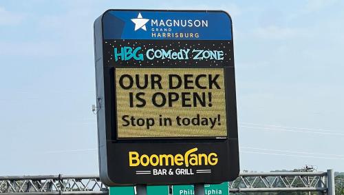 a sign that says our desk is open and stop in today at Magnuson Grand Harrisburg in New Cumberland