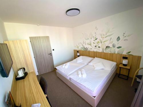a bedroom with a white bed with two pillows on it at STEELHOUSE Hotel in Třinec