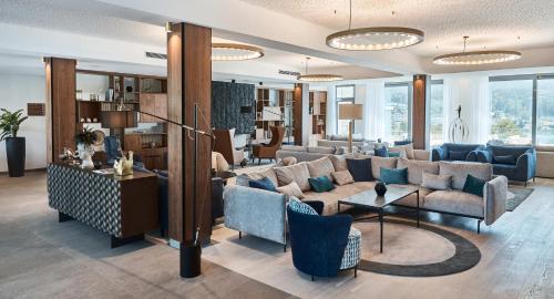 a living room with a couch and chairs and tables at Hotel Karnerhof in Egg am Faaker See