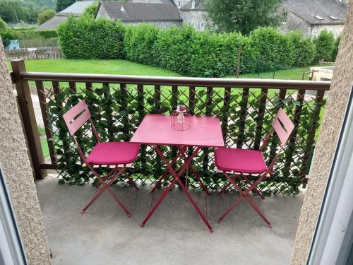 a pink table and two pink chairs on a balcony at La Campana 104 in Bielle