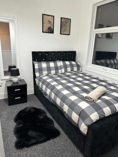 um quarto com uma cama xadrez em preto e branco em 3 bedroom house with garden in Tottenham london em Londres