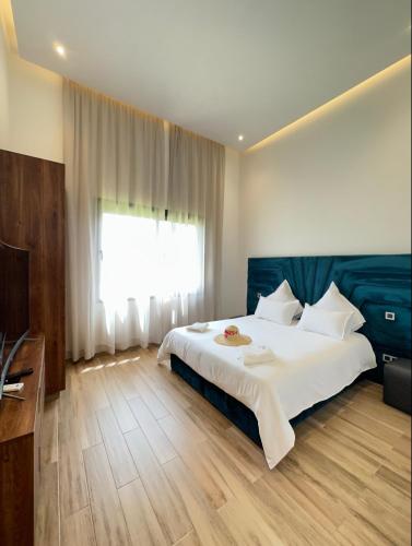 ein Schlafzimmer mit einem großen weißen Bett und einem Fenster in der Unterkunft Villa Jne Marrakech in Oulad Mazoug