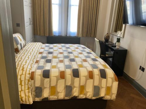 Queens View في لندن: غرفة نوم مع سرير وبطانية مقلية