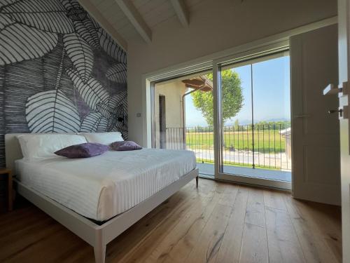 a bedroom with a bed and a large window at CASA VOLA in Cuneo