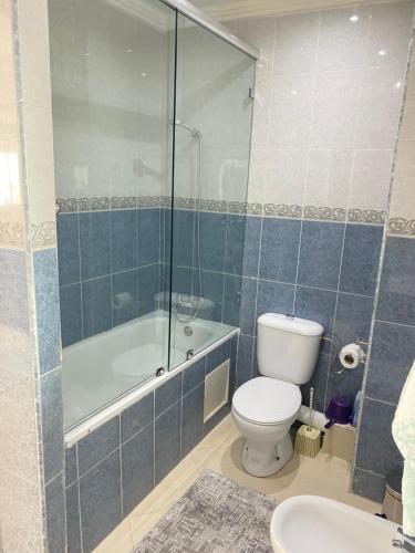 a bathroom with a toilet and a shower and a sink at Huge 4 bedroom Condo 2 min walking to TGV train in Kenitra