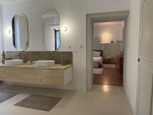 une salle de bain avec deux lavabos et un grand miroir dans l'établissement Grande Maison de Maitre contemporaine à 10 min de la mer et Piscine, à Salles-d'Aude