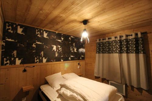 Cette petite chambre comprend un lit et un rideau. dans l'établissement 3 Biches, à Font-Romeu-Odeillo-Via