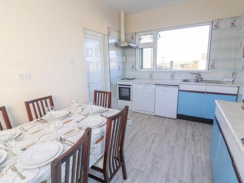 a dining room with a table and chairs and a kitchen at Mullagh Road in Miltown Malbay